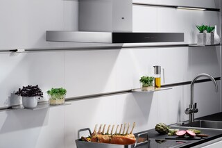 Essen köchelt auf einem Electrolux Induktionskochfeld, während die Dunstabzugshaube den Dampf automatisch absaugt.
