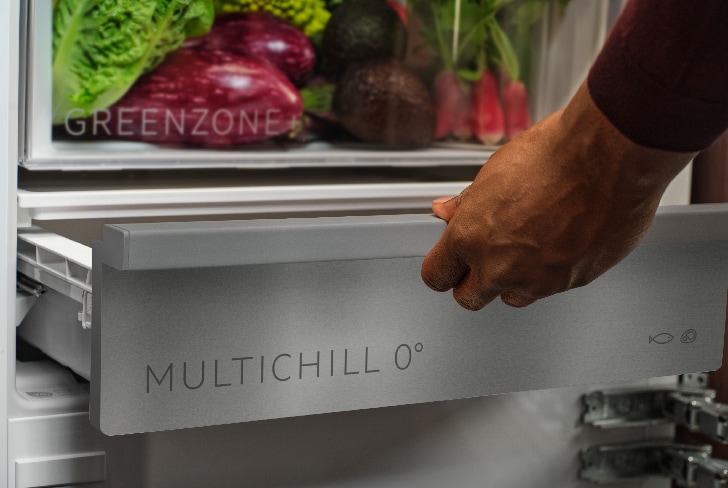 Mann zieht die Multichill-Schublade im Kühlschrank heraus.