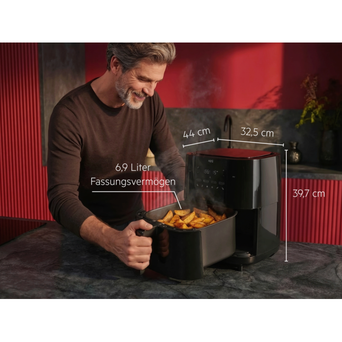 Airfryer mit herausgezogener Garschublade voller Pommes, daneben Maßangaben und 6,9‑Liter‑Fassungsvermögen