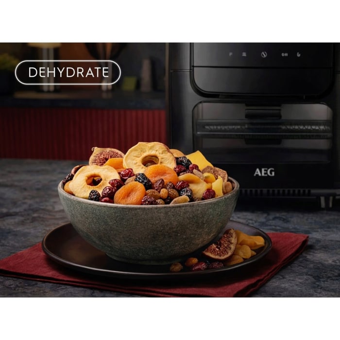 Schale mit verschiedenen Trockenfrüchten vor einem Airfryer; links oben das Symbol ‚DEHYDRATE‘