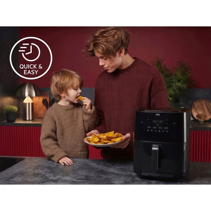 Zwei Personen in einer Küche neben einem Airfryer; einer hält einen Teller mit Kartoffelstücken. Links das Symbol ‚Quick & Easy‘
