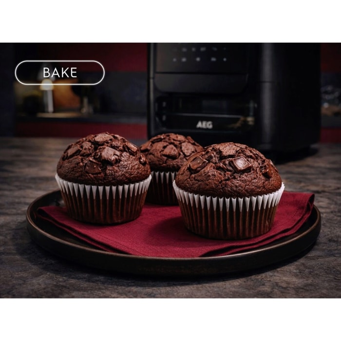 Drei Schokomuffins auf Teller mit rotem Tuch; im Hintergrund ein Airfryer. Links oben Bake‑Symbol