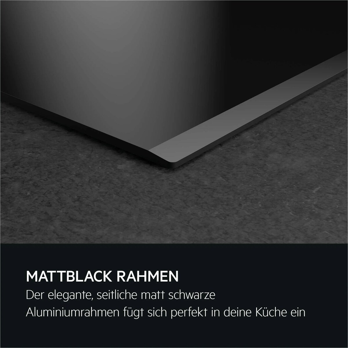 Nahaufnahme eines Kochfelds mit seitlichem matt schwarzem Aluminiumrahmen auf dunkler Steinoberfläche.