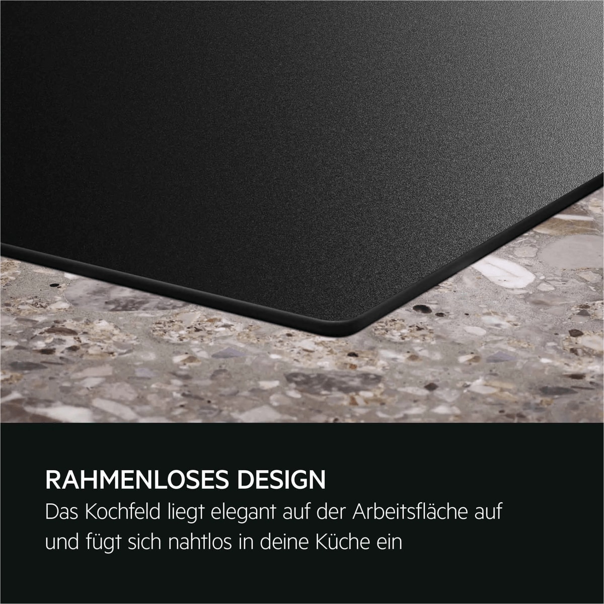 Nahaufnahme einer schwarzen, rahmenlosen Kochfeldecke auf einer hellen Stein-Arbeitsplatte.