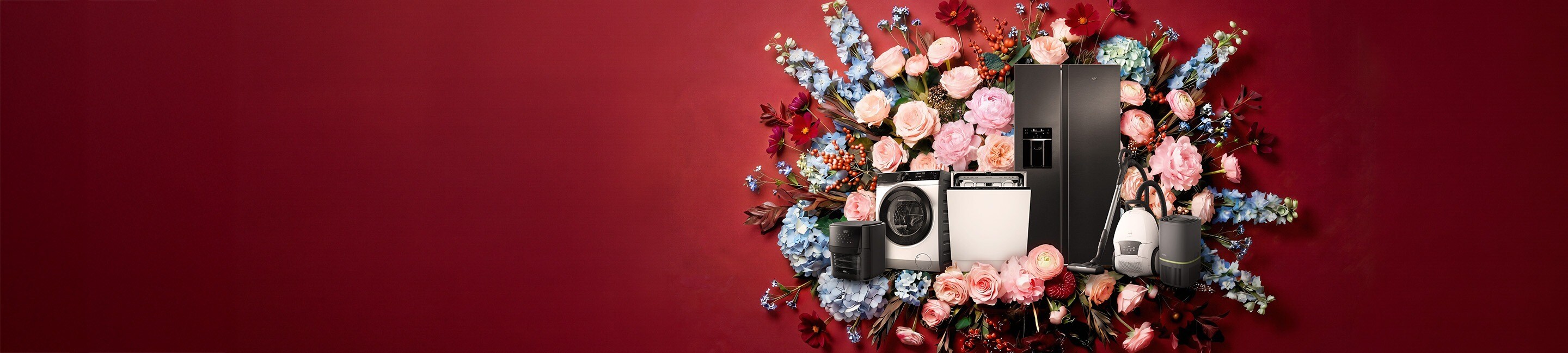 Verschiedene moderne Haushaltsgeräte, darunter ein schwarzer Side-by-Side-Kühlschrank, eine Waschmaschine, ein Geschirrspüler, ein kompakter Haushaltshelfer sowie kabellose Reinigungsgeräte, arrangiert vor einem großen Bouquet aus farbenfrohen Blumen auf dunkelrotem Hintergrund.