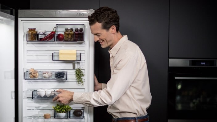 Mann öffnet Kühlschrank