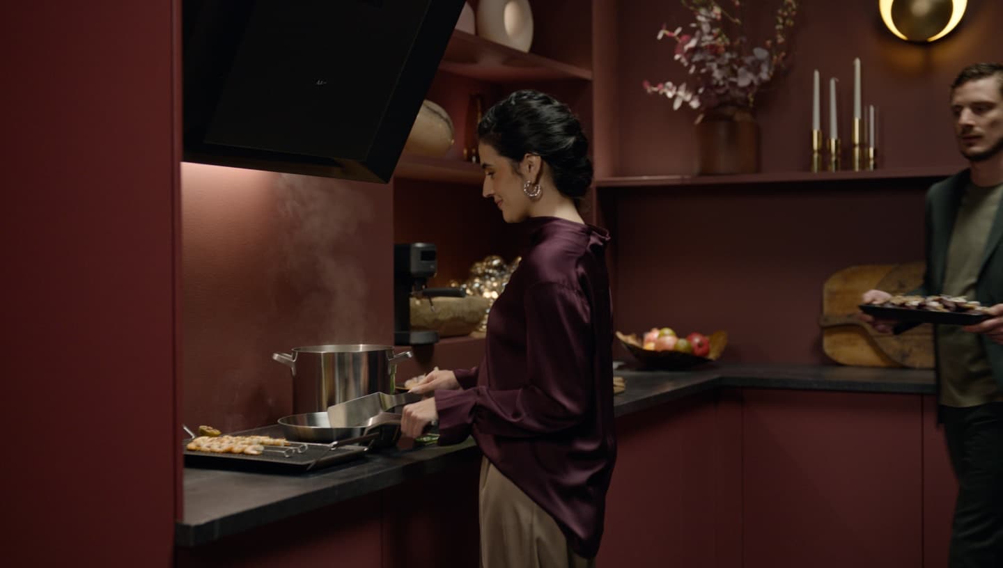Eine Frau und ein Mann bereiten in einer modernen Küche Essen zu.