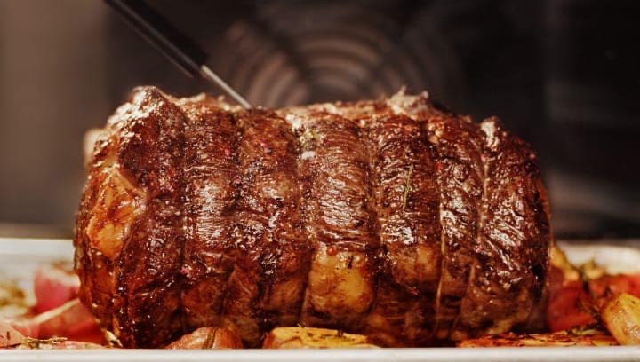 Ein Steak und Gemüse werden in einem Backofen zubereitet.