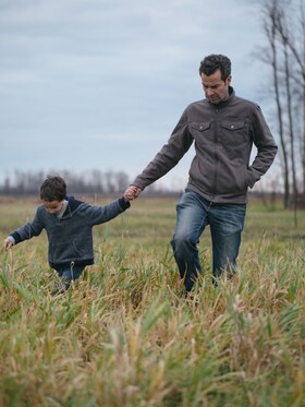 Mark Schatzker und sein Sohn gehen über eine Wiese