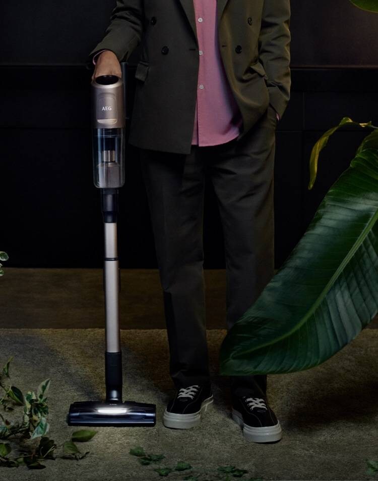 Stehende Person mit einem Akku-Staubsauger 8000 in der Hand