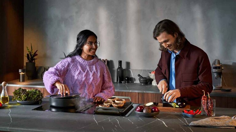 Zwei Personen bereiten in einer Küche eine Mahlzeit zu.