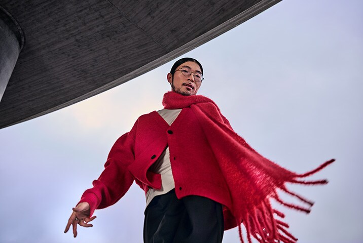 Mann in einem roten Wollpullover mit Schal