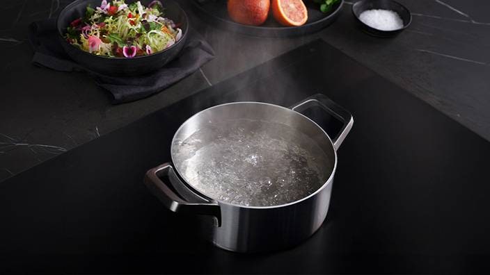 Ein Topf mit kochendem Wasser auf einem Induktionskochfeld