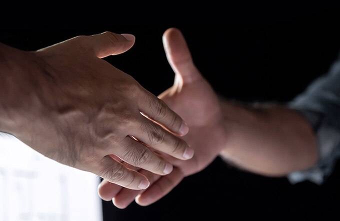 Zwei Menschen geben sich die Hand